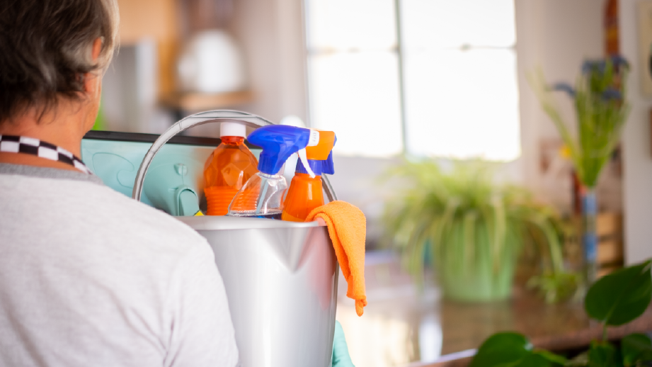 senior woman holding cleaning stuff